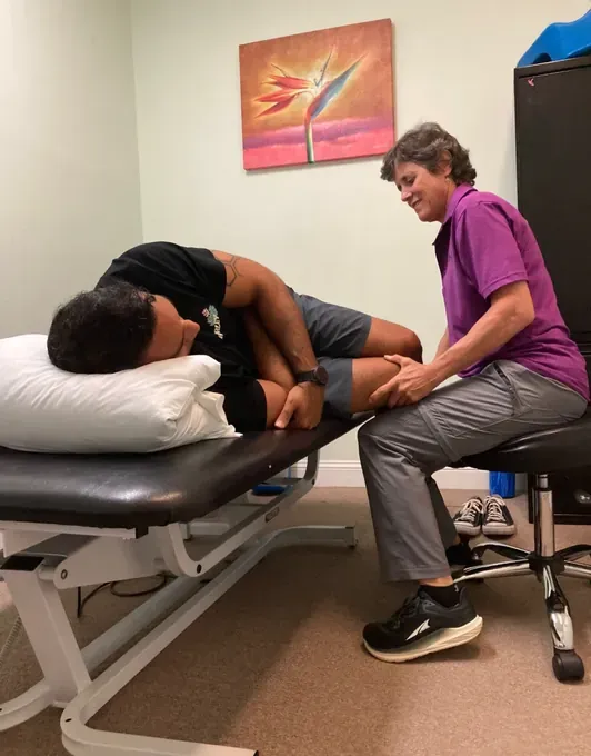 A therapist providing hands-on treatment to a patient's hip
