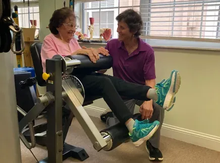 A therapist guiding a patient through a strengthening exercise